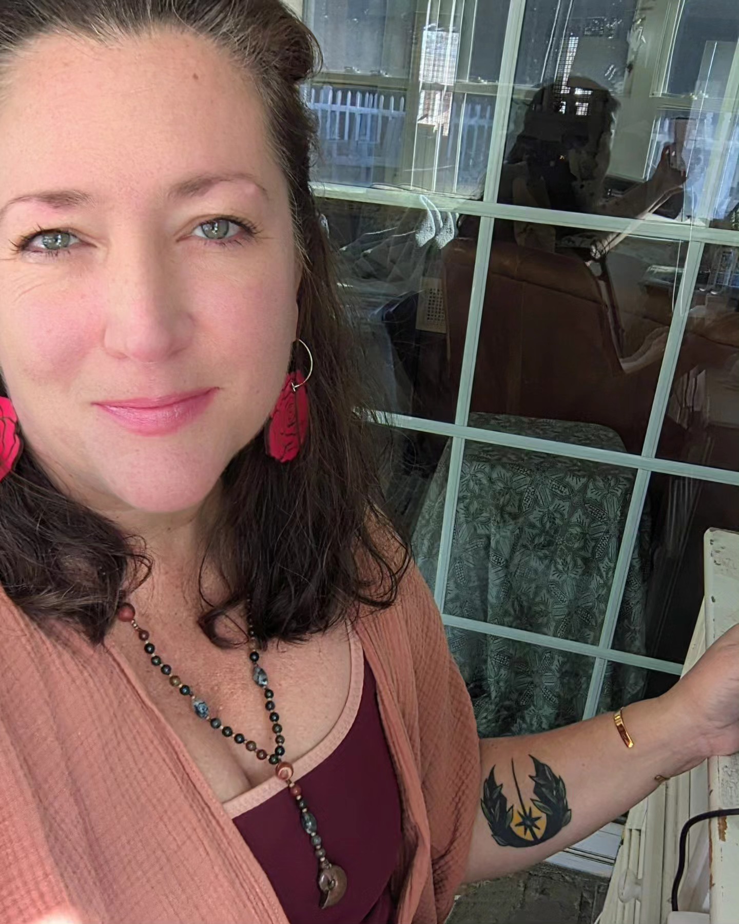 Woman standing in front of a window looking at camera.